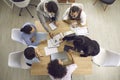 Top view of businesspeople working with laptops and and documents sitting at one desk. Royalty Free Stock Photo