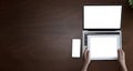 Top view of businesswoman sitting at white desk and uses smartphone on table are laptop and digital tablet with blank screen.Girl Royalty Free Stock Photo