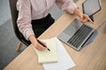 Top view of a businesswoman working at her desk, using laptop and taking notes on her notepad Royalty Free Stock Photo