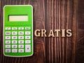 Top view calculator and wooden word with text GRATIS on a wooden background