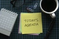 Top view of a calendar, glasses, paper clips, a cup of coffee and memo notes written with Today's Agenda on green square Royalty Free Stock Photo