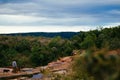 Top view of a calm water cascade in Cachoeira das Andorinhas in Ouro Preto surrounded greenery, red rocks and a group of people