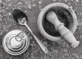 Top view of a can of packaged food, a wooden mortar and a metal spoon on a spotted background, in black and white Royalty Free Stock Photo