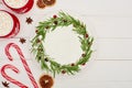 Top view of candy canes, two cups of cocoa and christmas pie with icing on white wooden table.