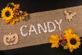 Top view of the Candy word and artificial flowers on a linen fabric