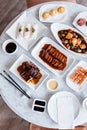 Top view of Cantonese meal including BBQ Pork, Roasted Duck, Fresh Shrimp Spring Rolls, Deep fried snapper fillets. Royalty Free Stock Photo