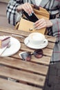 Top view on cappuccino cup , cheesecake on plate on table. Female with smartphone and bag.