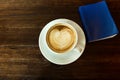 Top view cappuccino or latte coffee with heart shape with book