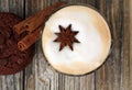 Top view of Cappuccino with star cinnamon sticks. Chocolate chip cookie.