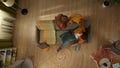 Top view capturing a young couple having a playful pillow fight. The woman got over a man who is laying on the couch. Royalty Free Stock Photo