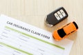 Top view of car insurance claim form with car key and car toy on Royalty Free Stock Photo