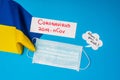 Top view of card with coronavirus 2019-nCov lettering, medical mask and where is your mask on speech bubble with flag of