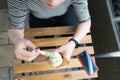 Top view of caucasian hand woman holding plastic spoon eating Vanilla cone ice cream and cell phone on wooden table at cafe place Royalty Free Stock Photo