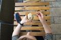 Top view of caucasian hand woman holding plastic spoon eating Vanilla cone ice cream and cell phone on wooden table at cafe place Royalty Free Stock Photo