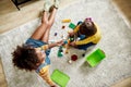 Top view of caucasian little girl spending time with african american baby sitter, playing with construction toys set Royalty Free Stock Photo