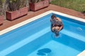 Top view of a caucasian man that takes a bomb dive in the swimming pool on a sunny day Royalty Free Stock Photo