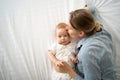 Top view, caucasian mother and her toddler baby on the bed, close-up. Mother& x27;s love, guardianship. Health care and Royalty Free Stock Photo