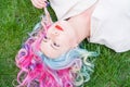 Top view of Caucasian woman with multi-colored hair lying on green grass. Royalty Free Stock Photo