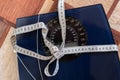 top view of the centimeter tape with knot bow on the weigher scales, the diet concept Royalty Free Stock Photo