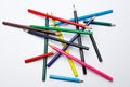 top view of a chaotic pile of color pencils, looking like mikado game on white and uniform background Royalty Free Stock Photo
