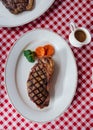 Top view of Charcoal grilled boneless wagyu Top Loin steak served with BBQ sauce and baked potato.