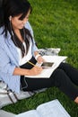 Top view of charming asian female student taking notes, while li Royalty Free Stock Photo