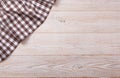 Top view of checkered tablecloth on white wooden table.