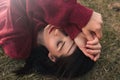 Top view of beautiful young Caucasian woman smiling and closed eyes, wearing knitted pullover, lying on the grass. Royalty Free Stock Photo