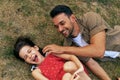 Top view of a cheerful father playing with his daughter on the grass outdoors. Dad enjoying at day out with his child in the park Royalty Free Stock Photo