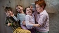 Top view of cheerful mother with three little children lying on floor together at home. Royalty Free Stock Photo