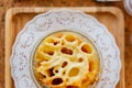 Top view of Cheese Baked Penne in glass bowl on wooden plate with salt, pepper and cutlery Royalty Free Stock Photo