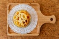 Top view of Cheese Baked Penne in glass bowl on wooden plate with salt, pepper and cutlery Royalty Free Stock Photo