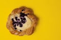 Top view of cheese danish puff pastry with blackberries and vanilla custard on punchy yellow background