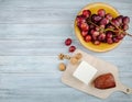 top view of cheese smocked and feta cheese on a wooden cutting board with walnuts and sweet grape in a plate on rustic background Royalty Free Stock Photo