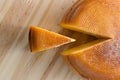 Top view of cheese wheel and slice over a wooden table Royalty Free Stock Photo