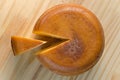 Top view of cheese wheel and slice over a wooden table Royalty Free Stock Photo