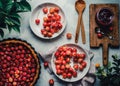 Top view of a cherry pie on a white background with a selection of fresh cherries around it