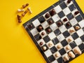 Top view of chessboard with chess pieces on yellow background Royalty Free Stock Photo