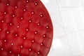 Top view of a chic red round sofa with shiny buttons. Luxurious design of upholstered furniture