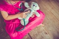 Child playing doctor or nurse with plush toy bear at home. Vintage tone effect. Royalty Free Stock Photo