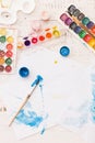 Top view on child`s drawings and colorful paints and brushes. Creative ideas, creativity andearly learning. Education concept Royalty Free Stock Photo