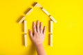 Top view of child`s hand close up building blocks showing home, house, wooden hut Royalty Free Stock Photo