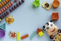 Top view on children`s educational games, frame kids toys on blue paper background. Cubes, stars, circles, cow, ladybug