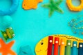 Top view on children`s educational and music games, frame from multicolored kids toys on light blue paper background. Circles,