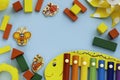 Top view on children`s educational and music games, frame from multicolored kids toys on light blue paper background Royalty Free Stock Photo