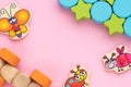 Top view on children`s educational toys, multi-colored cubes, stars,circles on a pink background. Cute butterfly, ladybug, bee,