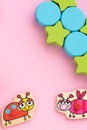 Top view on children`s educational toys, stars,circles on a pink background. Cute puzzle ladybug, bee. Flat lay, copy