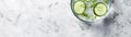 Top View Chilled Cucumberinfused Water On Marble. Banner For Web. Generative AI