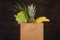 Top view of chinese cabbage, pineapple and bananas in shopping bag