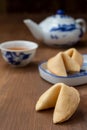 Top view of Chinese fortune cookies, teapot and cup, on wooden table, with selective focus Royalty Free Stock Photo